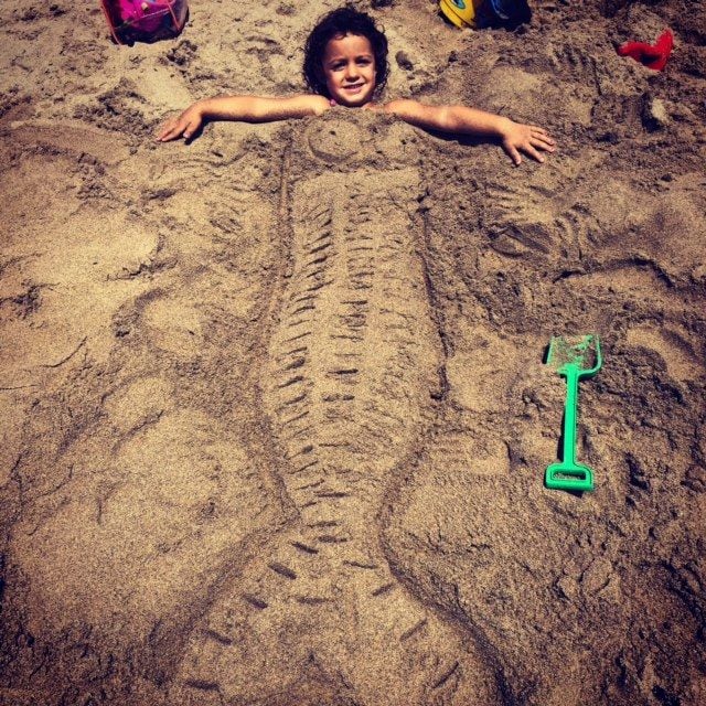 Chloe en la playa enterrada como sirenita